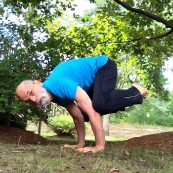 man performing crow position exercise