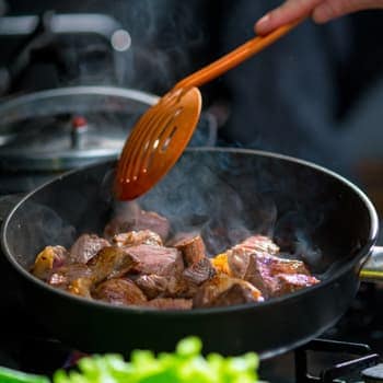 Sauteing meat over a hot stove