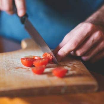 Slicing cherry tomatoes on a cutting board