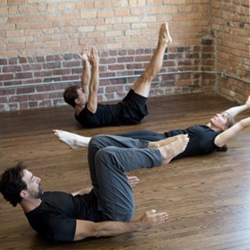 Group of people doing hollow body holds