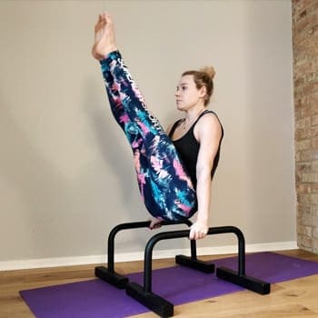 Verity doing V-Sit exercise on parallettes