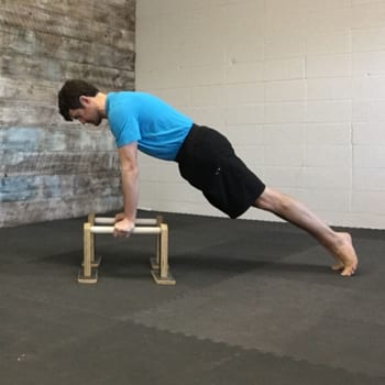 Jeff doing plank exercise on parallettes