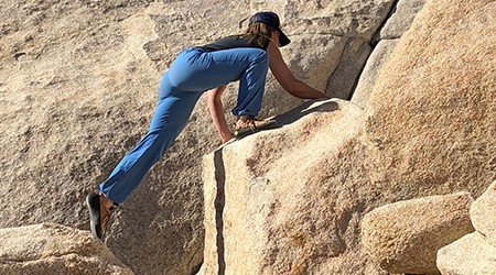 woman stretching between rocks while climbing