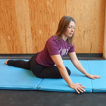 A woman practicing the modified pigeon stretch