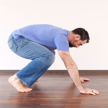 Burpees Don’t Have to Suck: Stop Chasing Reps and Start Training Smarter 1 Person demonstrating a strong, grounded squat—starting position for a controlled burpees